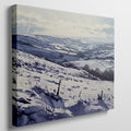 Framed canvas print of a snowy countryside landscape with rolling hills in cool blue tones