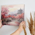 Framed canvas print of a traditional Asian cherry blossom landscape with pagodas and a serene river