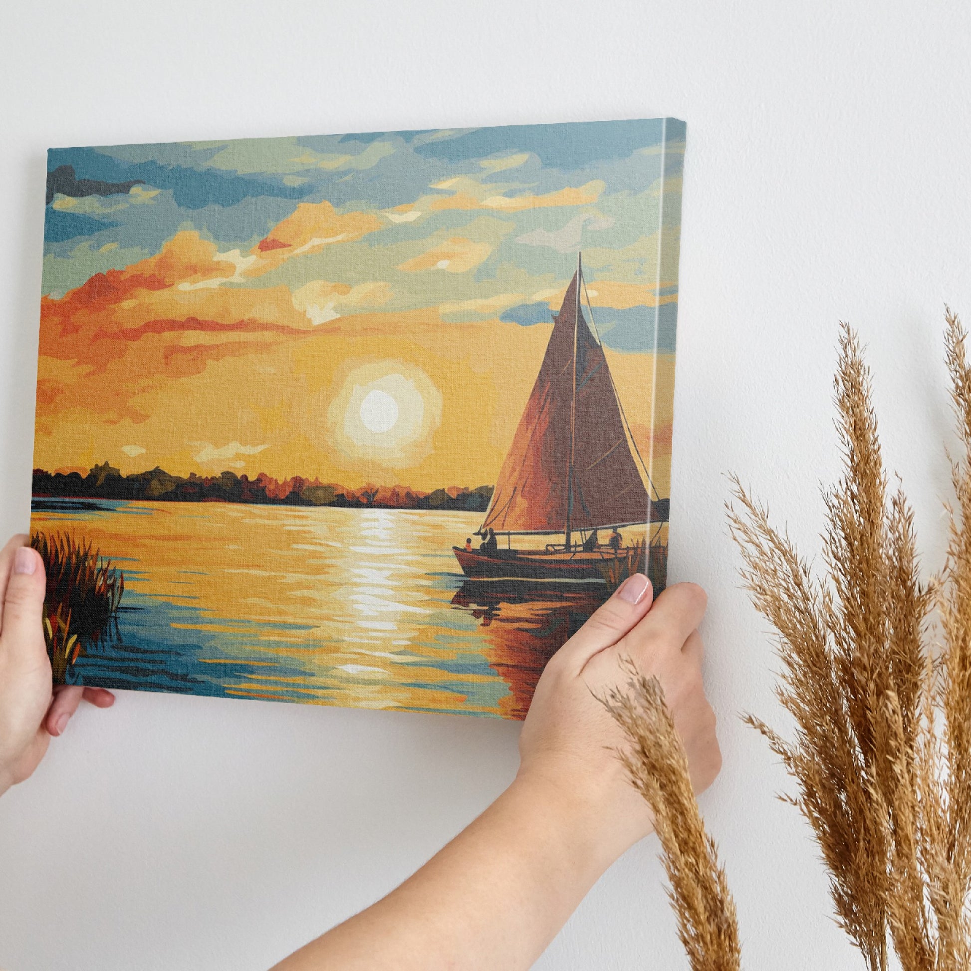 Vibrant sunset over water with a silhouette of a sailboat and reflective sunlight on the ocean