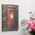 Framed canvas print of a classic British red postbox surrounded by greenery