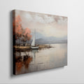 Framed canvas print of an impressionist painting with a sailing boat and autumn trees by a lake