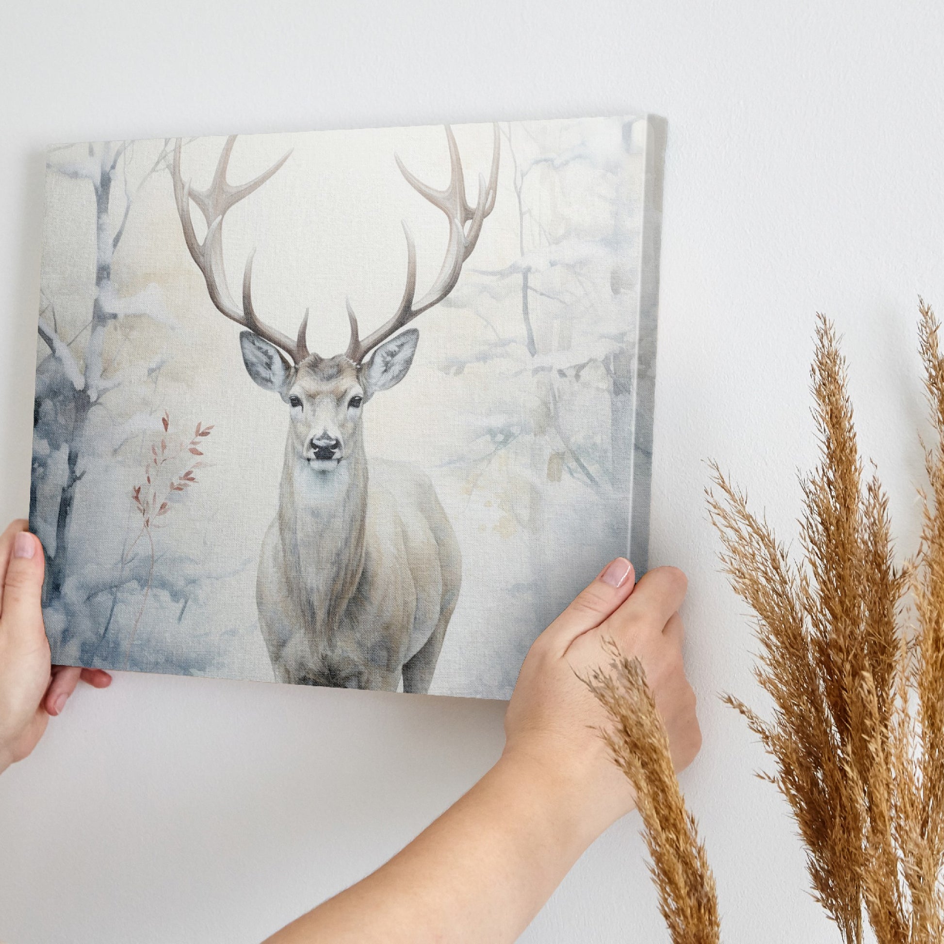 Framed canvas print of a majestic stag set against a snowy forest backdrop with soft beige and white tones