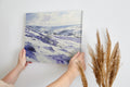 Framed canvas print of a serene winter landscape with snow-covered hills and valleys