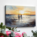 Framed canvas print of a couple walking on the beach at sunset with reflective water and warm colours