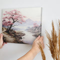 Framed canvas print of a serene cherry blossom landscape with mountains and a river