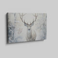 Framed canvas print of a majestic stag set against a snowy forest backdrop with soft beige and white tones