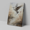 Framed canvas print of a heron soaring above a sepia-toned riverside scene with blooming reeds.