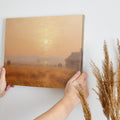 Framed canvas print of a misty, Impressionist-style sunset over a rustic countryside landscape with warm tones