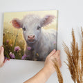 Framed canvas print of a realistic calf in a meadow with pink and yellow flowers