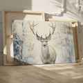 Framed canvas print of a majestic stag set against a snowy forest backdrop with soft beige and white tones