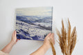 Framed canvas print of a snowy countryside landscape with rolling hills in cool blue tones