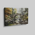 Framed canvas print of a tranquil autumnal scene featuring a rustic stone bridge over a serene river with lush forest in the background