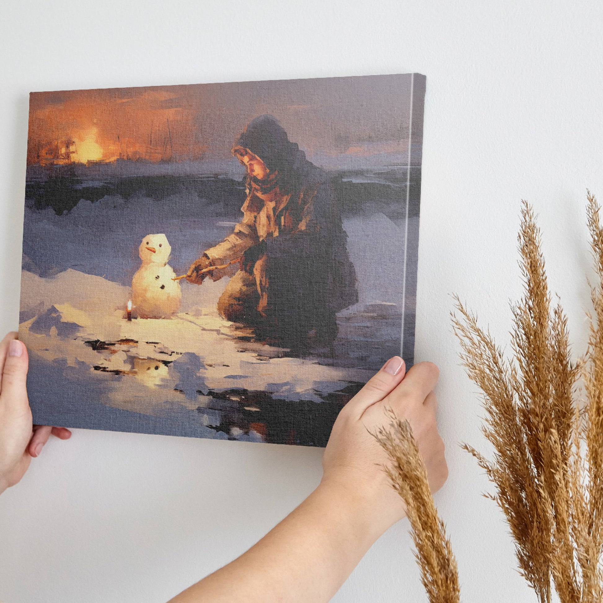 Framed canvas print of a person building a snowman at sunset with a winter landscape