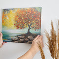 Impressionistic painting of a tree with golden autumn leaves by the coast on canvas