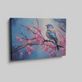 Framed canvas print of a bluebird perched on cherry blossom branches, with vibrant blue and pink hues