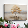 Framed canvas print of a solitary tree with autumn leaves reflected on a calm lake with warm beige, gold, and white tones