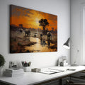 Framed canvas print of African elephants walking beside water during a vibrant sunset