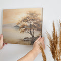 Autumnal landscape with a golden tree on a lakeshore and reflection in the water