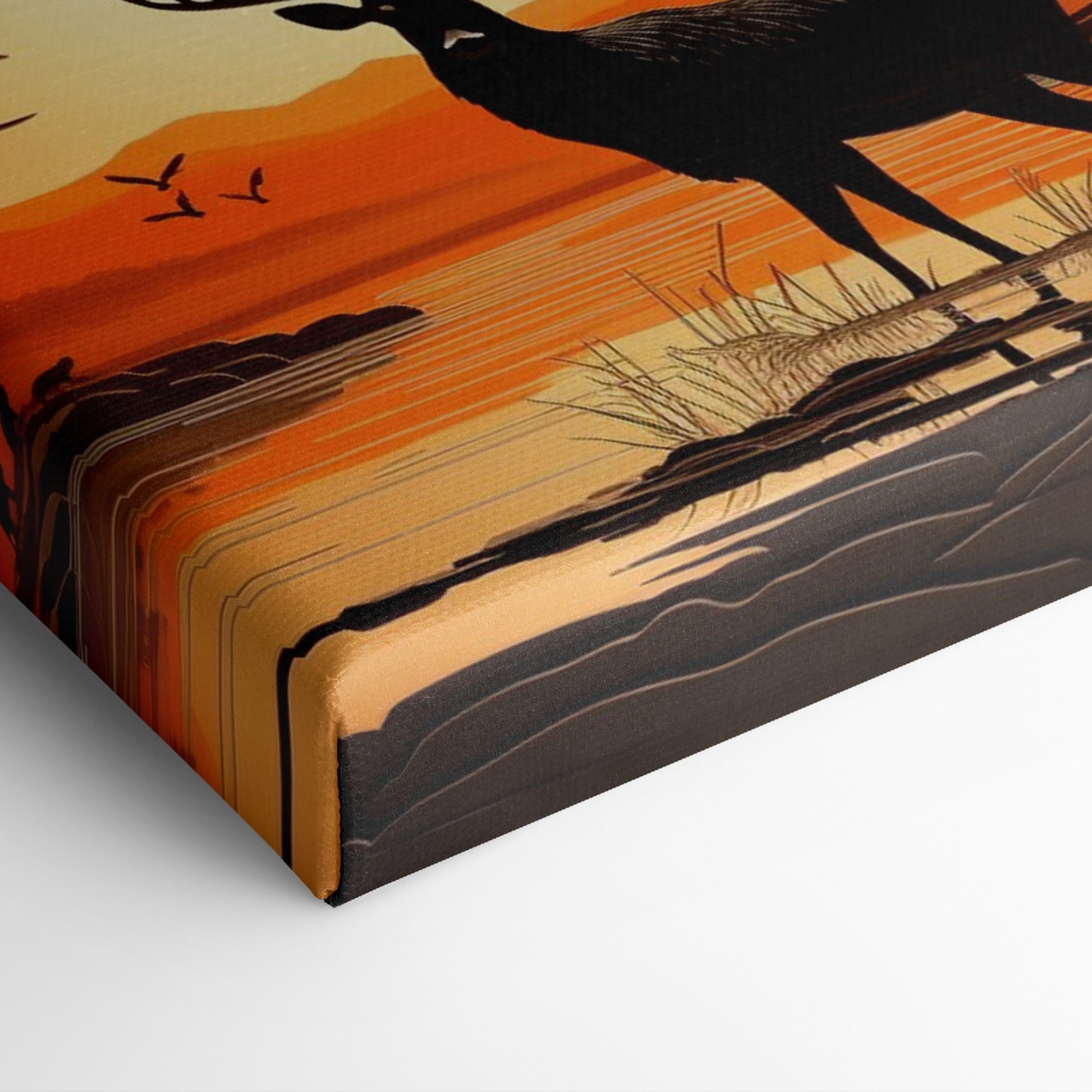 Printed canvas art of a black deer silhouette against an orange sunset with trees and mountains