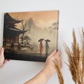 Framed canvas print of serene oriental pagoda scene with misty mountains and figures with umbrellas