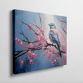 Framed canvas print of a bluebird perched on cherry blossom branches, with vibrant blue and pink hues