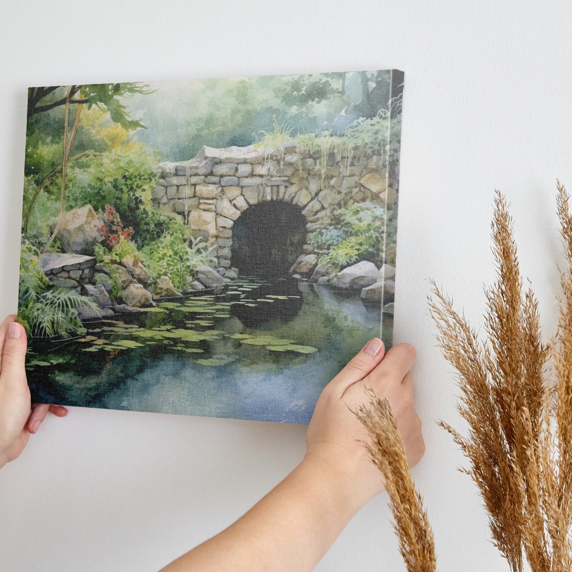 Framed canvas print of a serene watercolor painting of a rustic stone bridge over a calm pond with water lilies