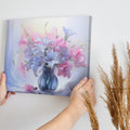 Framed canvas print of a realistic floral still life with pastel pink and blue flowers in a vase