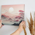 Framed canvas print of a tranquil pink sunrise over mountains with a reflective lake and silhouette of a tree