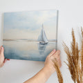 A serene painting of a sailboat on calm blue waters under a vast sky, reflecting a peaceful coastal scene.