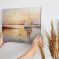 Impressionistic painting of a sailboat on calm waters at sunset with vibrant orange and yellow tones reflecting on the water.