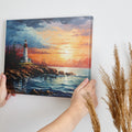 Framed canvas print of a vibrant impressionist sunset over a lighthouse and ocean