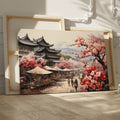 Framed canvas print of a traditional Japanese town during cherry blossom season with pink florals and historic architecture