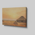 Framed canvas print of a rustic thatched cottage in a countryside landscape at sunset with warm golden and orange hues