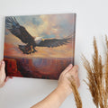 Framed canvas print of a majestic eagle in flight over a canyon at sunset with warm shades of orange and blue