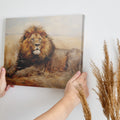 Framed canvas print of a realistic lion resting in the golden savannah