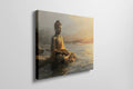 Wall canvas print of a meditative Buddha statue in golden and orange hues reflecting on tranquil waters at sunrise.