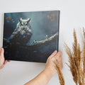 Framed canvas print of a mystical owl with amber eyes perched on a branch against a dark, moody background with autumn leaves