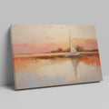 Framed canvas painting of a sailboat at sunset with orange and beige sky reflected in calm blue waters