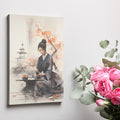 Framed canvas print of a serene Japanese woman in kimono participating in a tea ceremony with cherry blossoms and pagoda in the background