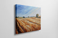 Framed canvas print of golden wheat fields under a blue sky in a rural landscape