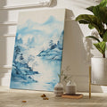 Framed canvas print of a tranquil blue watercolour landscape with misty mountains, silhouetted trees, and flying birds