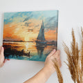 Framed canvas print of an impressionist painting depicting a sailboat at sunset with vibrant oranges and blues