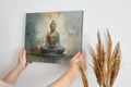 Framed canvas print of a serene Buddha in meditative pose with abstract earthy background