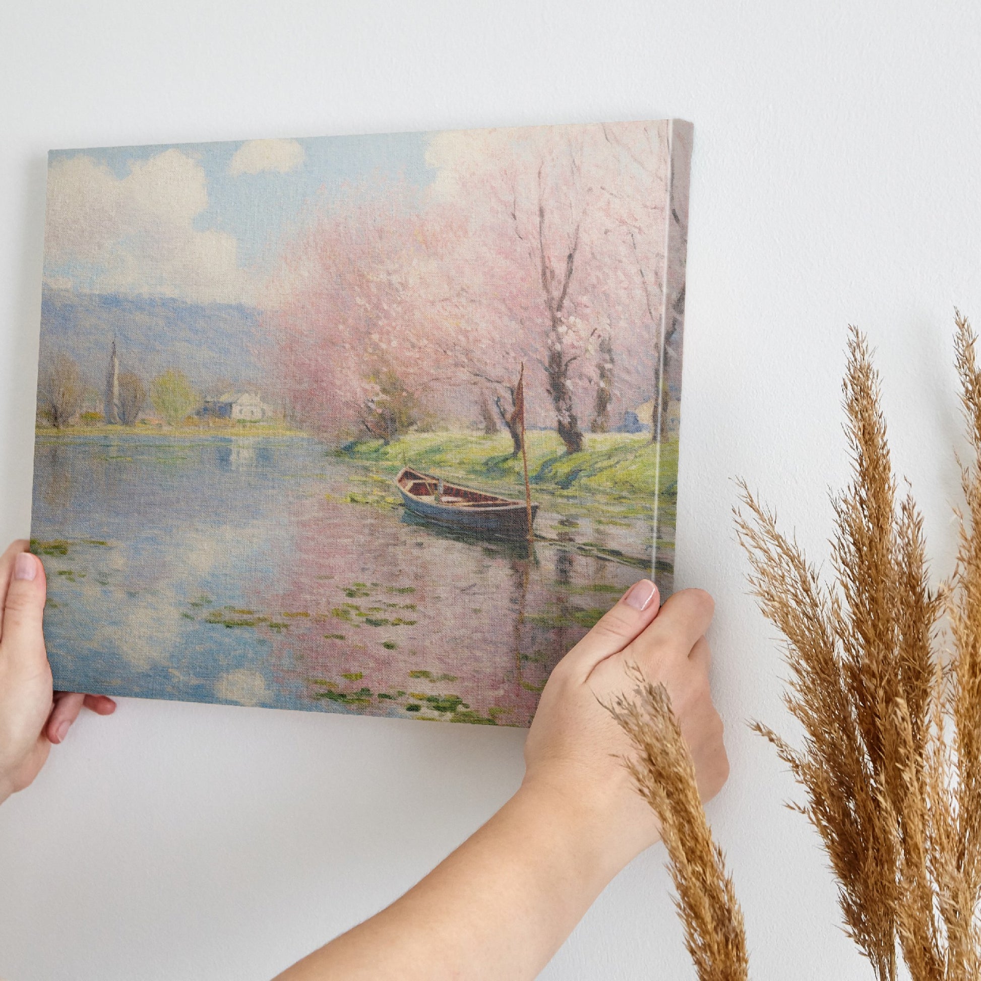 Framed canvas print of a tranquil river landscape featuring blooming cherry blossoms and a boat, in Impressionist style