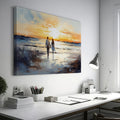 Framed canvas print of a couple walking on the beach at sunset with reflective water and warm colours