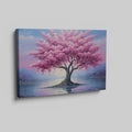 Framed canvas print of a blossoming cherry tree by the water with sunset reflection