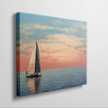 Sailboat on calming ocean waters during a vibrant sunset with orange and pink clouds in the sky.