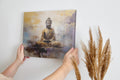 Framed canvas print of a golden Buddha in meditative pose with abstract background