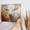 Framed canvas print of realistic cow in a floral setting with warm tones