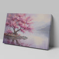 Framed canvas print of a cherry blossom tree by a tranquil lake at dusk with mountains in the background, reflecting soft pink and purple hues